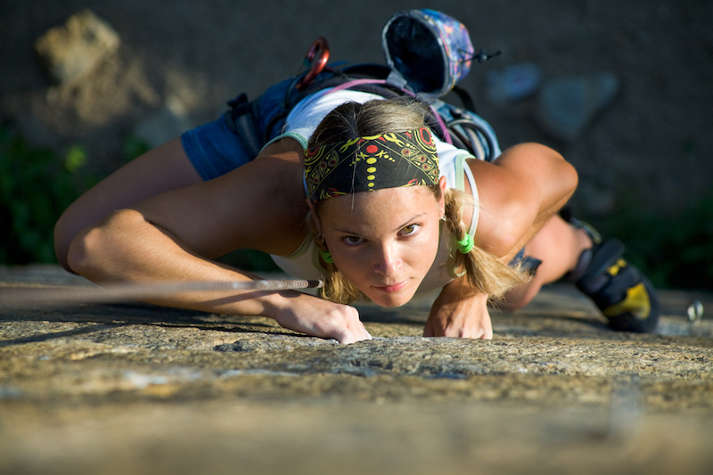 Vertical image of woman doing exercise on the mountain