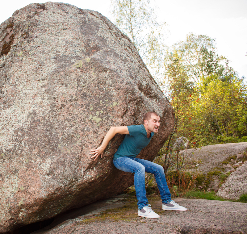 Too Ambitious: Man pushing a huge stone