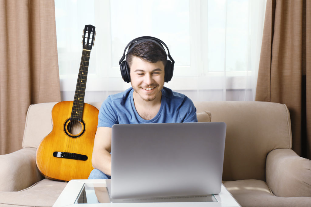 Young man taking music lessons over Skype