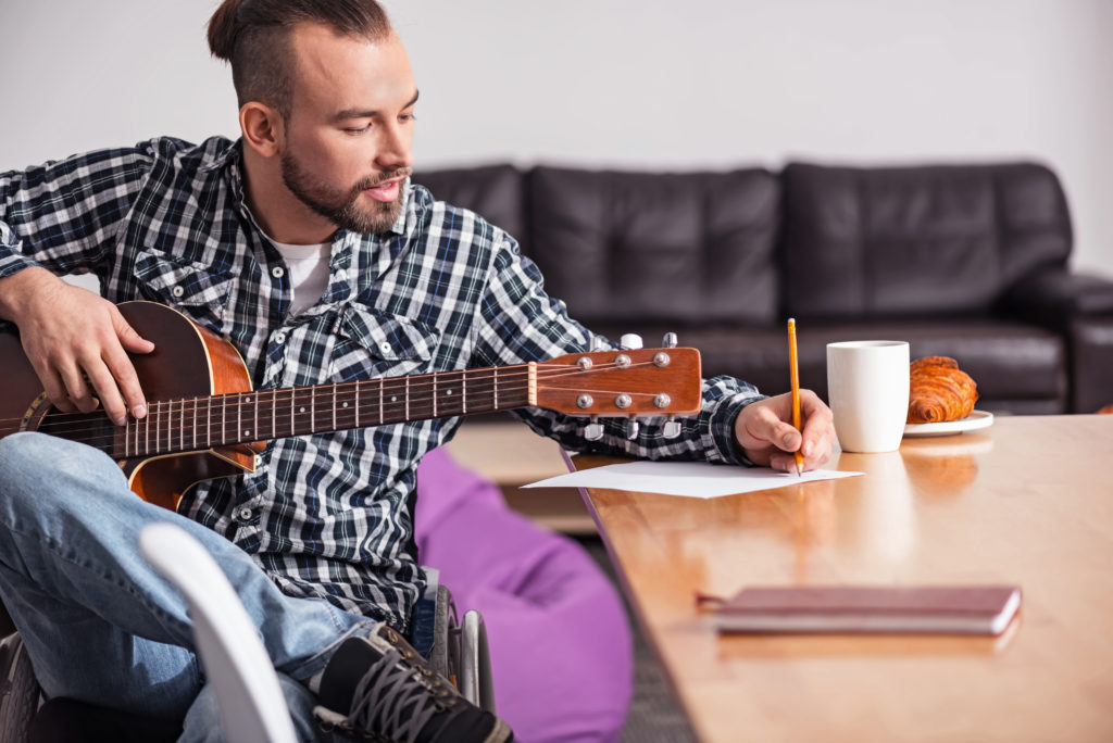 Man doing a songwriting challenge with guitar