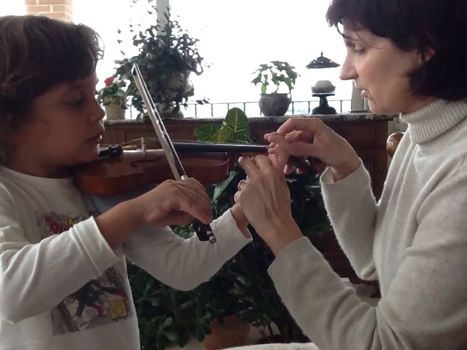 Eloise teaching a student violin
