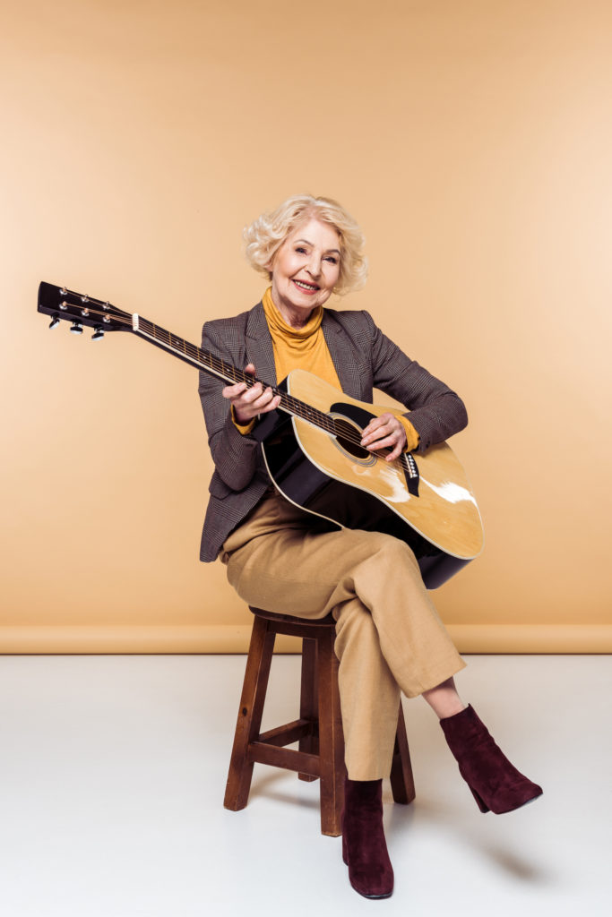 Elderly woman playing guitar
